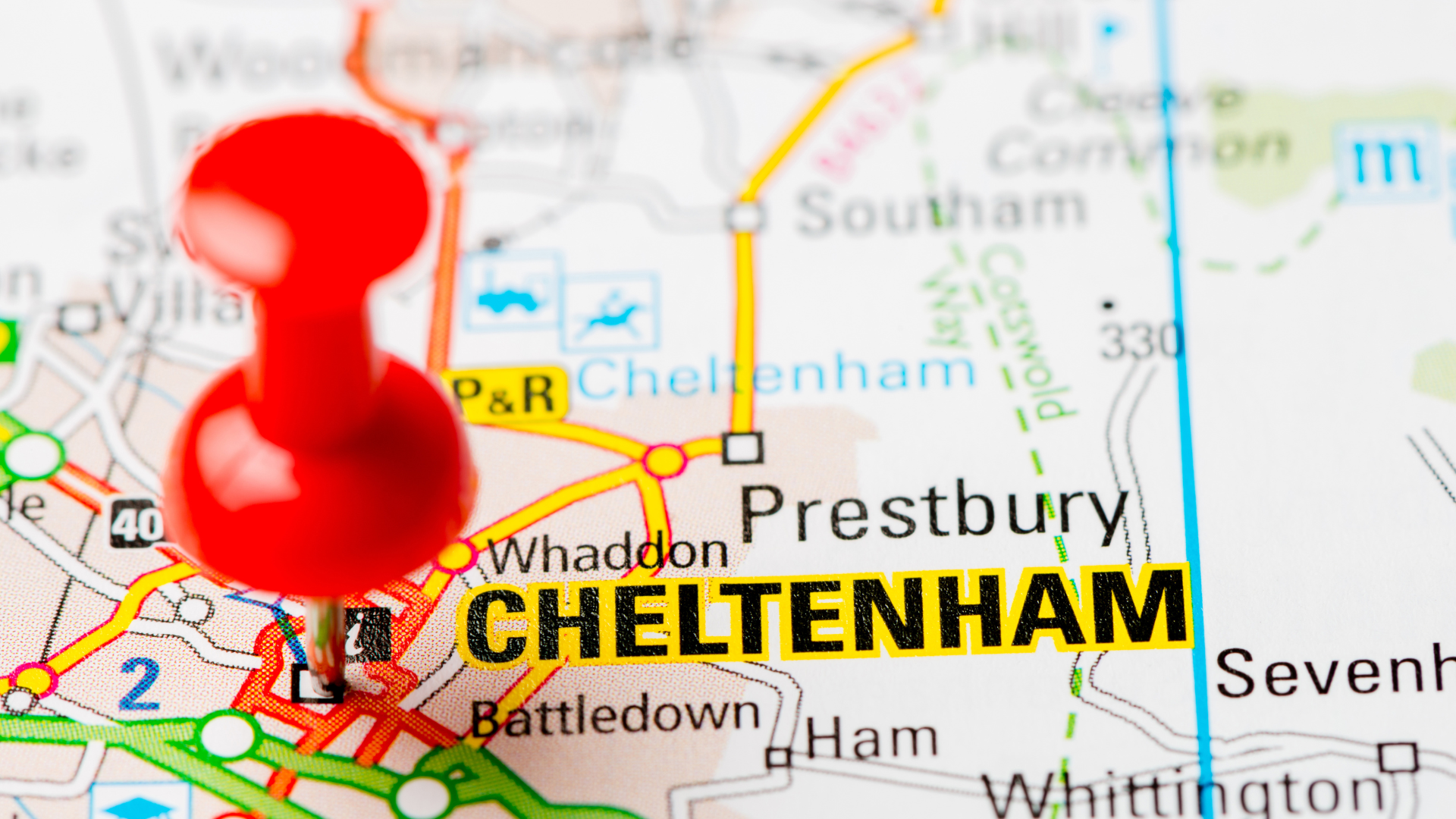 A road map of Cheltenham and the surrounding villages, with a red pin marking the town.